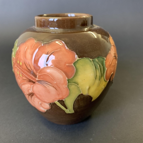 79 - Moorcroft 'Coral Hibiscus' pattern vase on a brown ground, approx. 3