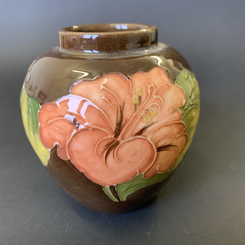 79 - Moorcroft 'Coral Hibiscus' pattern vase on a brown ground, approx. 3