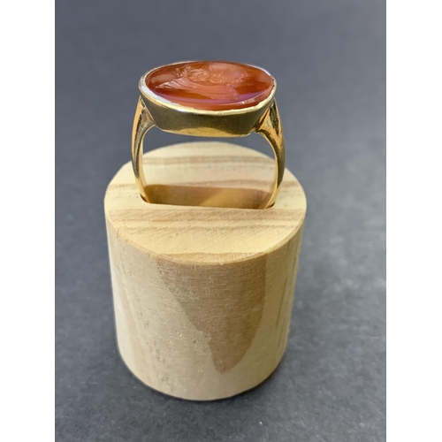 133 - A gold ring set with carved carnelian seal, possibly of Shakespeare, marks rubbed but '18' is visibl... 