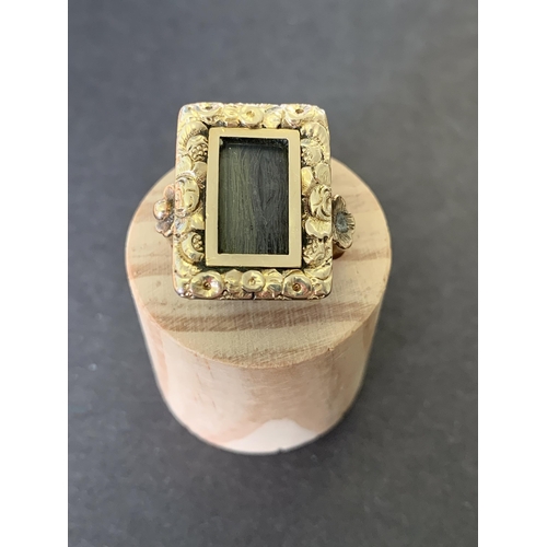 138 - An antique Victorian 9ct gold mourning ring, the top section with preserved hair in an ornate settin... 