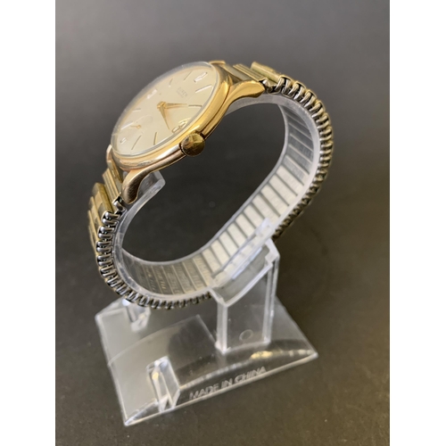 151 - A 9ct gold Buren Grand Prix wristwatch on elasticated yellow metal strap and with engraving on the b... 