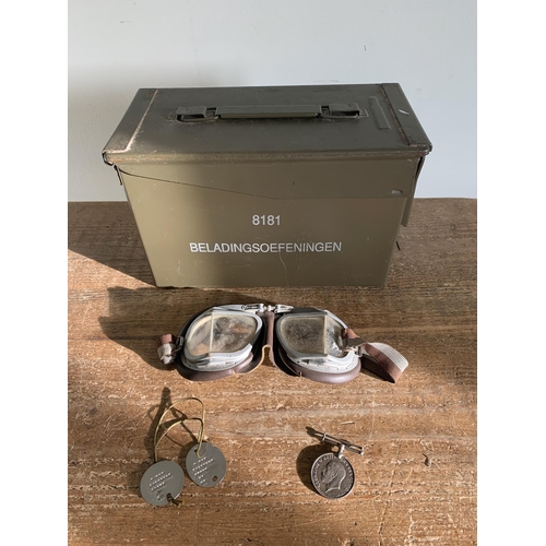 208 - A vintage ammunition tin plus a pair of vintage goggles, a pair of dog tags and a WW1 British war me... 