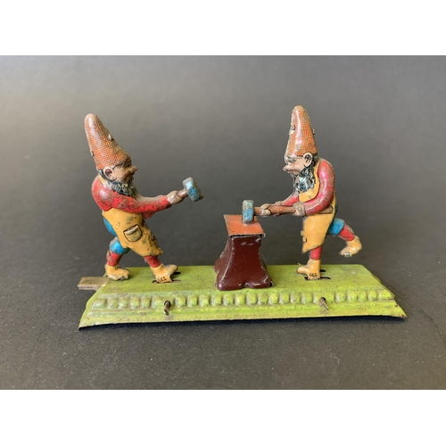 222 - An antique tin plate figure group of gnomes hitting an anvil, possibly by 'Meier' of Germany, marked... 