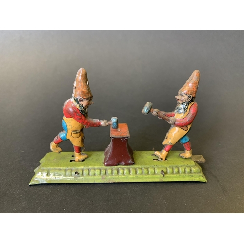 222 - An antique tin plate figure group of gnomes hitting an anvil, possibly by 'Meier' of Germany, marked... 