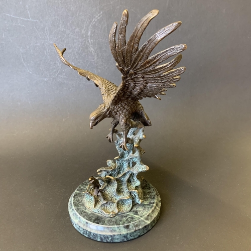 23 - A heavy bronze eagle hunting a salmon sat on a marble style vase, maker mark to back, 9 3/4