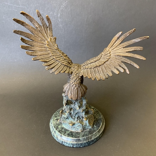 23 - A heavy bronze eagle hunting a salmon sat on a marble style vase, maker mark to back, 9 3/4