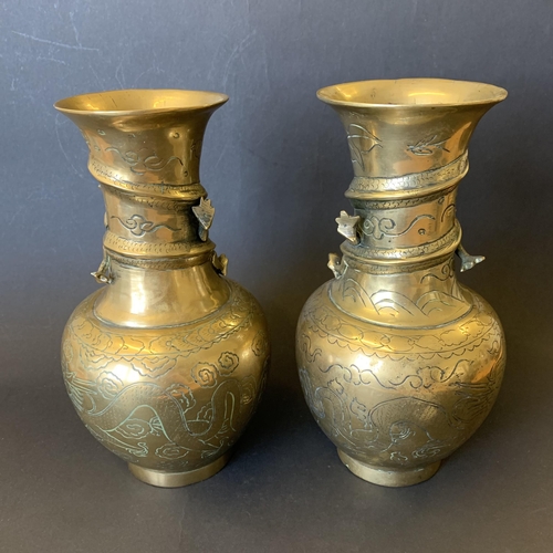 26 - A pair of Oriental polished bronze vases decorated with dragons, approx. 9