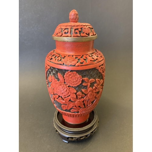 378 - A vintage Chinese carved cinnabar lacquer lidded jar/vase on wood stand, jar/vase is approx. 7 1/2