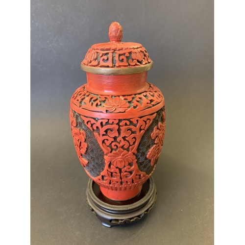 378 - A vintage Chinese carved cinnabar lacquer lidded jar/vase on wood stand, jar/vase is approx. 7 1/2