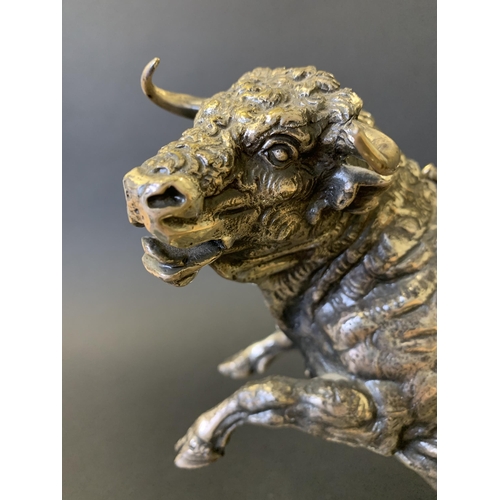 48 - A cast metal bull figurine with a white metal finish, in rearing pose with a sword in his back (and ... 