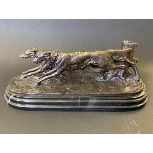 50 - After Antoine-Louis Barye, a bronze double figure group of dogs running, mounted on a black marble b... 