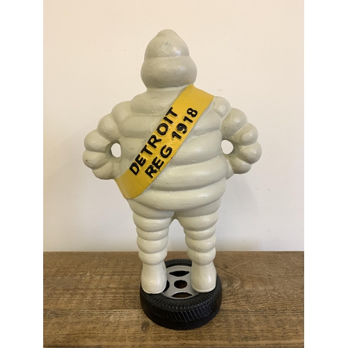 55 - A vintage cast iron Michelin style man marked 'Detroit Reg 1918' on back, the figure stood on a meta... 