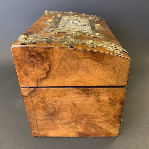 59 - An antique burr wood veneer double tea caddy, brass banded with central white metal figural scene pl... 