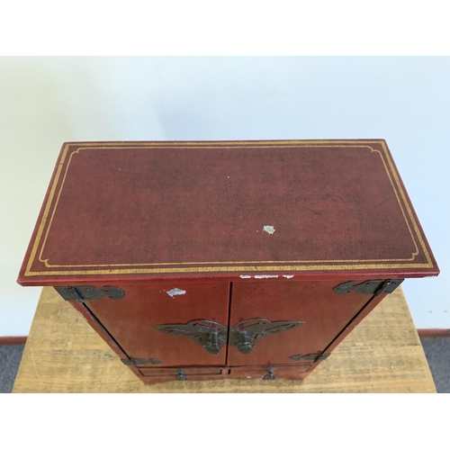 88 - A vintage Oriental style red painted jewellery cabinet with two drawers, stands 16