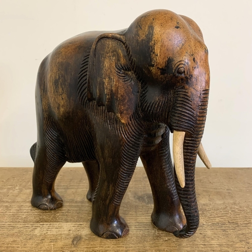 91 - A large carved wooden elephant with painted wood tusks, 10 1/2