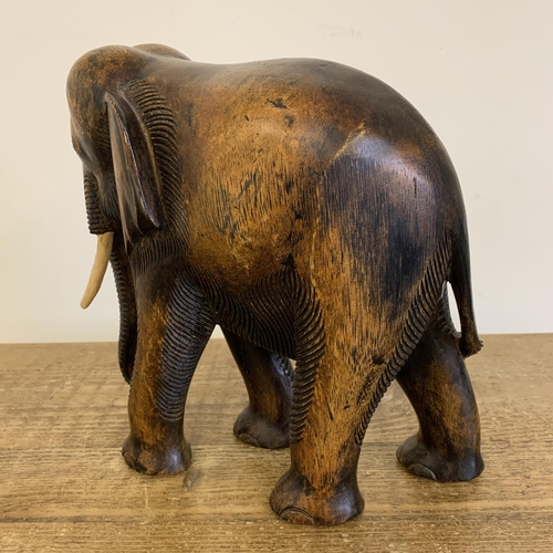 91 - A large carved wooden elephant with painted wood tusks, 10 1/2