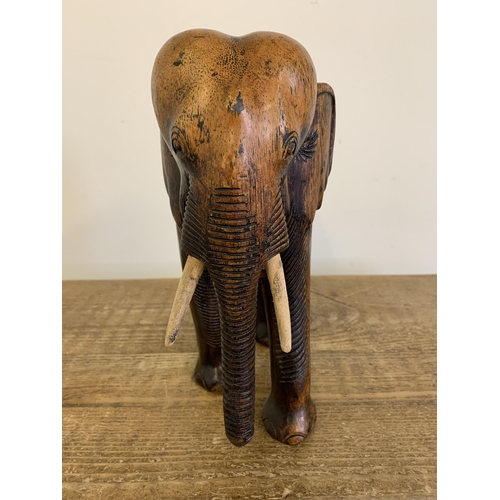 91 - A large carved wooden elephant with painted wood tusks, 10 1/2