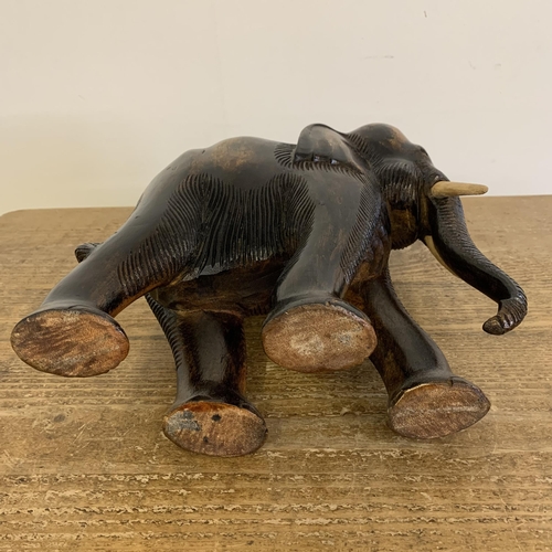 91 - A large carved wooden elephant with painted wood tusks, 10 1/2