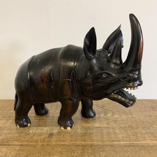 93 - An antique carved ebony rhinoceros with bone inset teeth and toenails, approx. 12 3/4