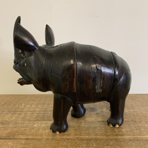 93 - An antique carved ebony rhinoceros with bone inset teeth and toenails, approx. 12 3/4