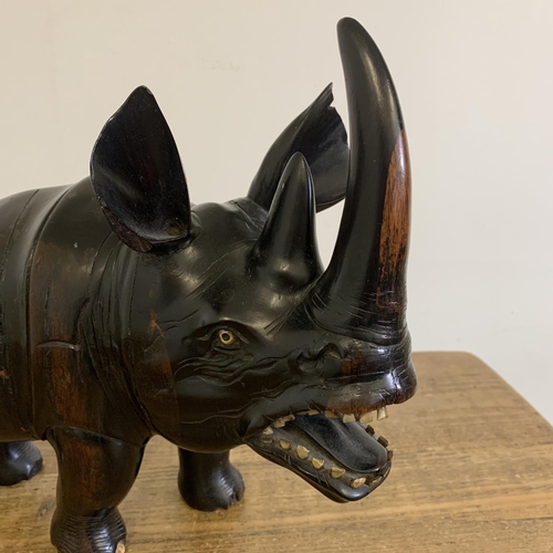 93 - An antique carved ebony rhinoceros with bone inset teeth and toenails, approx. 12 3/4