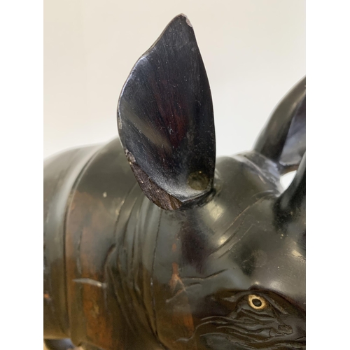 93 - An antique carved ebony rhinoceros with bone inset teeth and toenails, approx. 12 3/4