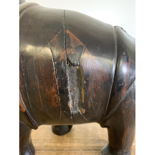 93 - An antique carved ebony rhinoceros with bone inset teeth and toenails, approx. 12 3/4