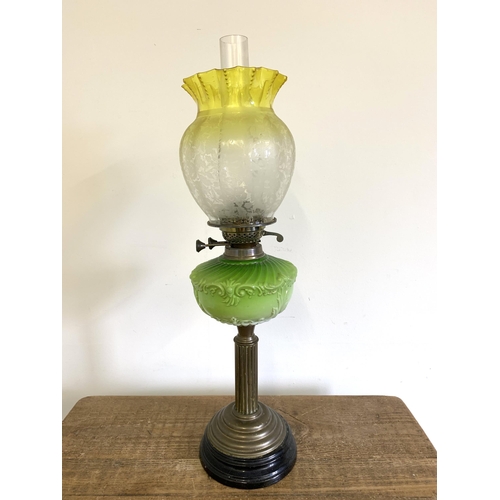 97 - A Victorian brass base oil lamp with green central reserve and uranium to clear glass shade, 26