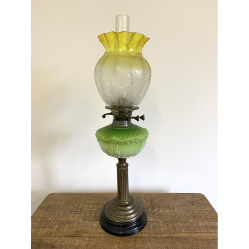 97 - A Victorian brass base oil lamp with green central reserve and uranium to clear glass shade, 26