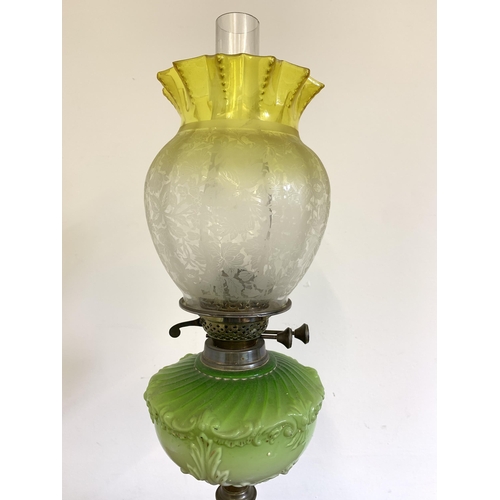 97 - A Victorian brass base oil lamp with green central reserve and uranium to clear glass shade, 26