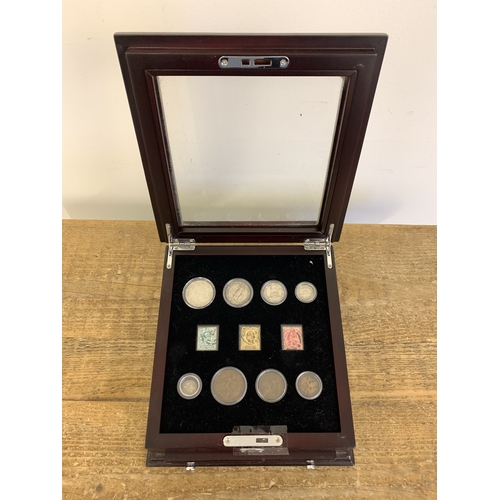 153 - Danbury Mint George V coins and stamp set housed in a wooden glazed case with drawer, silver weight ... 