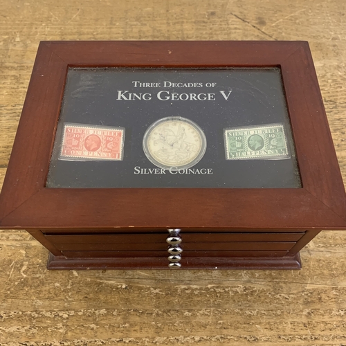 154 - Danbury Mint 'Three Decades of King George V' silver coinage and stamps housed in a wooden and glaze... 