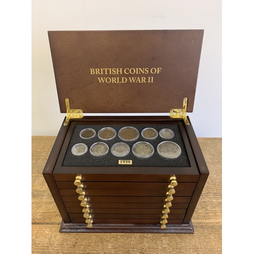 156 - Danbury Mint British coins of WW2 housed in a wooden display unit with eight drawers, pre 1947 silve... 