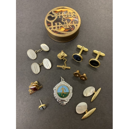 191 - A selection of cufflinks together with tie pins housed in a 'Studs & Links' tin