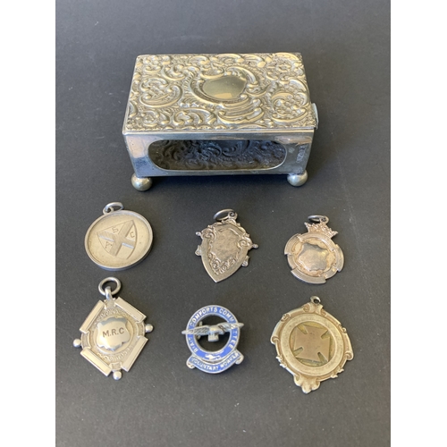 335 - A silver plated matchbox holder plus a selection of white metal fobs