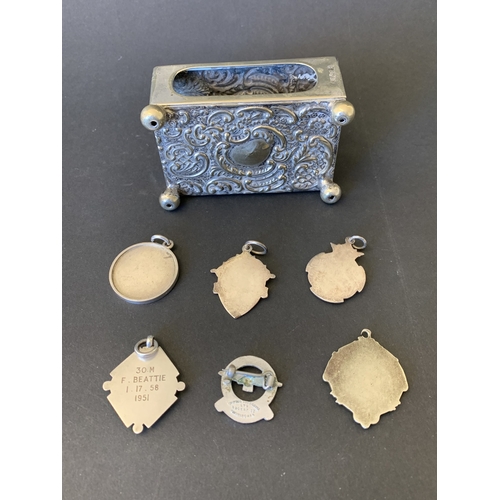 335 - A silver plated matchbox holder plus a selection of white metal fobs