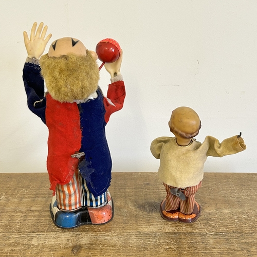 178 - A vintage Japanese battery operated tinplate and cloth juggling clown with whistle plus a small cloc... 