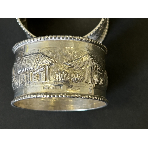 197 - A set of six sterling silver napkin rings decorated with elephants, trees and huts etc, total weight... 