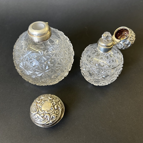 198 - Two cut glass perfume bottles with hallmarked silver hinged lids (some damage and wear noted, one li... 