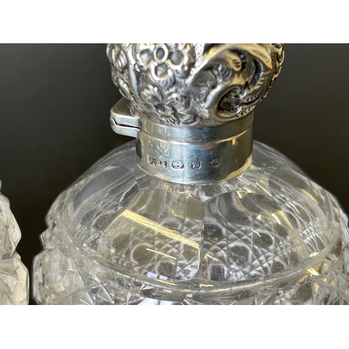 198 - Two cut glass perfume bottles with hallmarked silver hinged lids (some damage and wear noted, one li... 