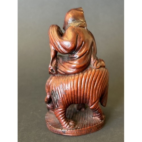 256 - A small finely carved wood figure seated on a elephant, approx. 4 1/4