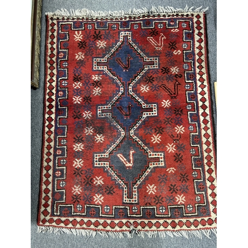 373 - A vintage red ground floor rug with birds within the pattern, 64