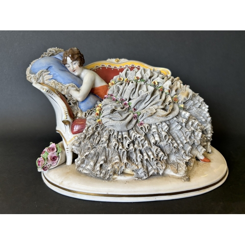 82 - A vintage Dresden porcelain lacework recumbent female figurine, bears a blue crown mark to the back,... 