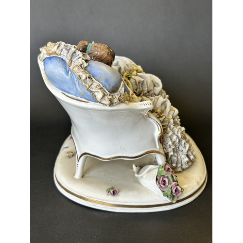 82 - A vintage Dresden porcelain lacework recumbent female figurine, bears a blue crown mark to the back,... 