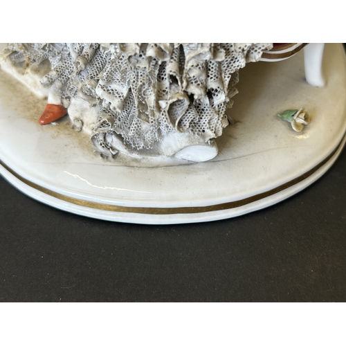 82 - A vintage Dresden porcelain lacework recumbent female figurine, bears a blue crown mark to the back,... 