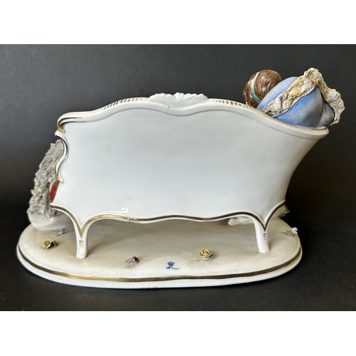 82 - A vintage Dresden porcelain lacework recumbent female figurine, bears a blue crown mark to the back,... 