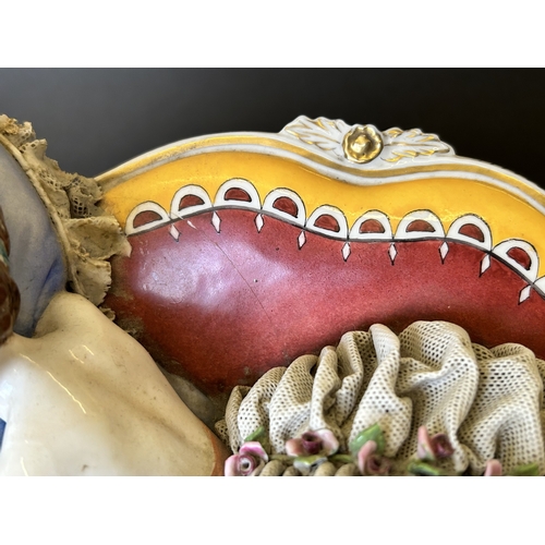 82 - A vintage Dresden porcelain lacework recumbent female figurine, bears a blue crown mark to the back,... 