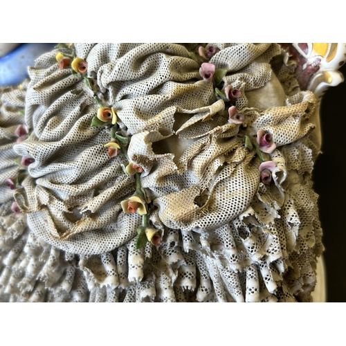82 - A vintage Dresden porcelain lacework recumbent female figurine, bears a blue crown mark to the back,... 