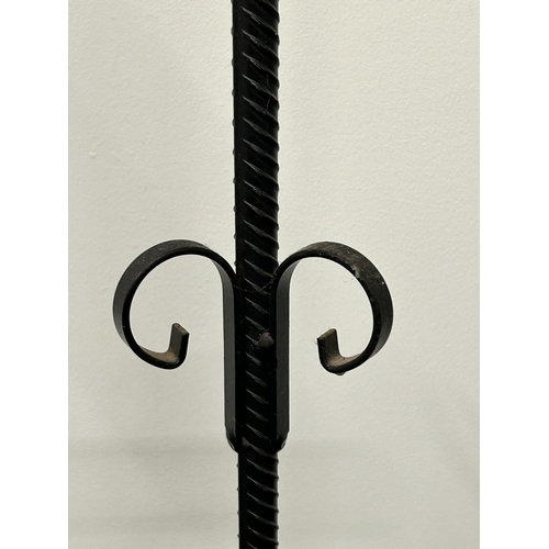476 - Two tall iron candle holders, the tallest approx. 40 1/2