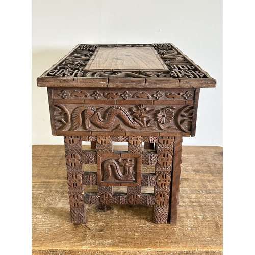 252 - An antique Chinese portable wooden fold-up scribe or reading table decorated with dragons to the top... 
